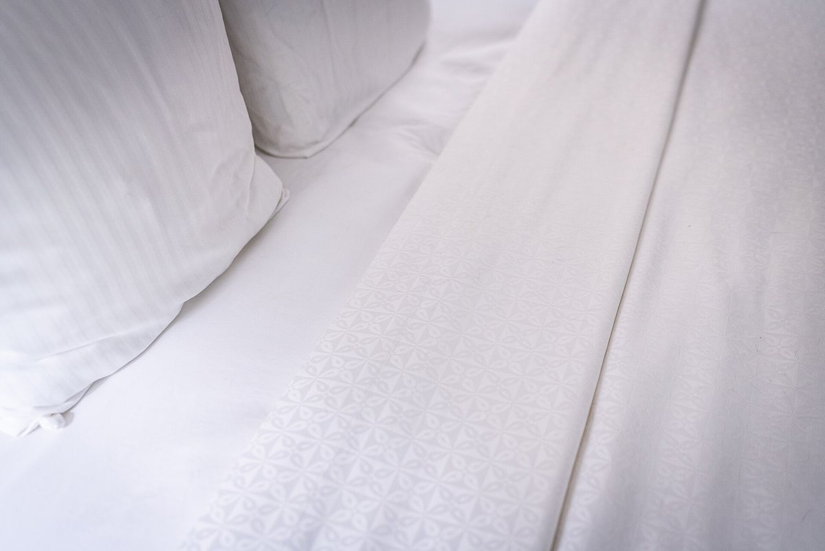 A neatly made bed with white pillows and sheets