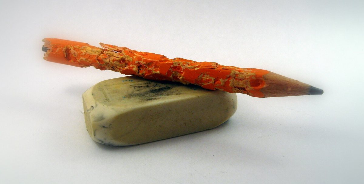 A short pencil and an eraser with a dirty black surface