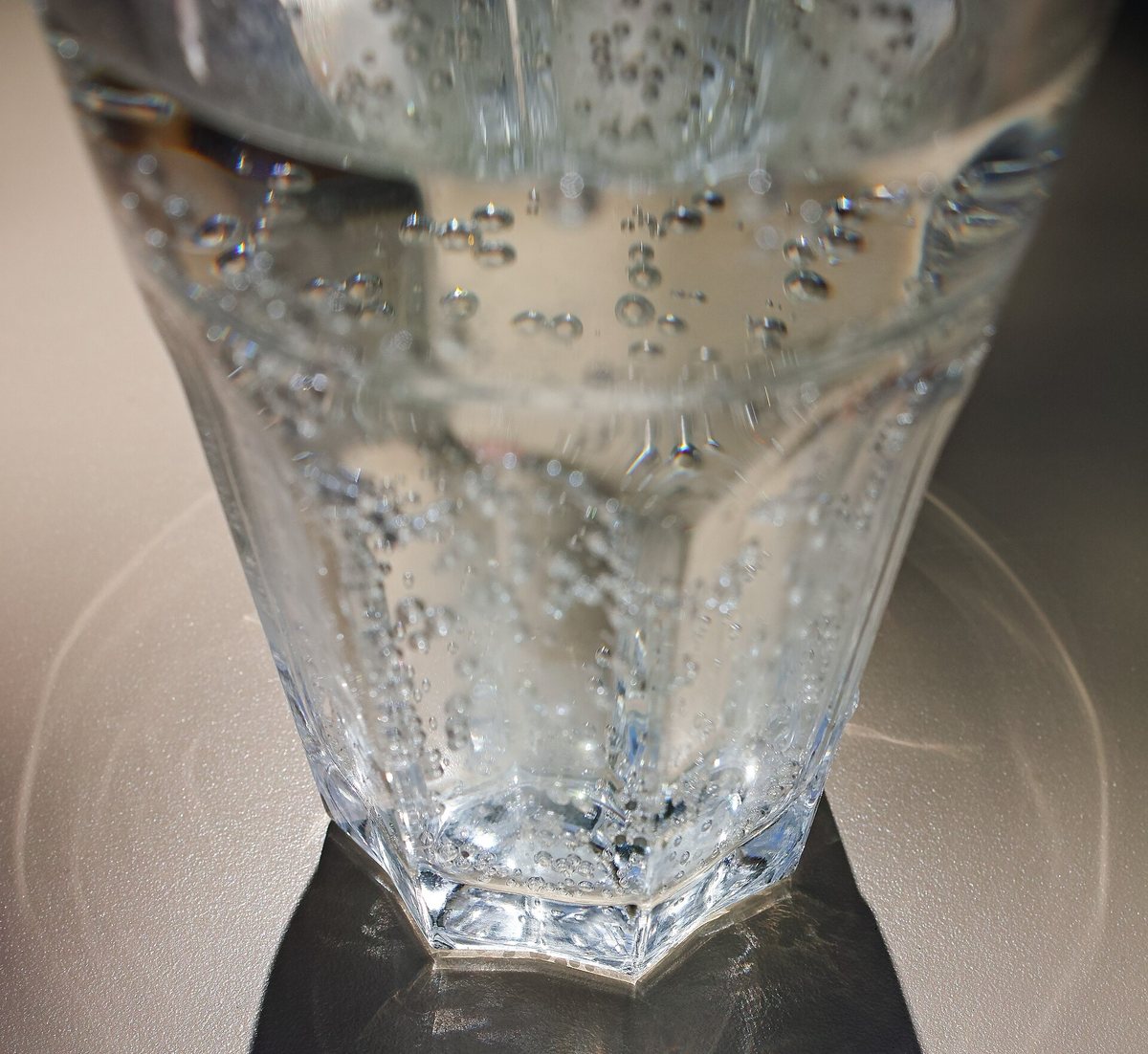 A glass of sparkling water with bubbles rising