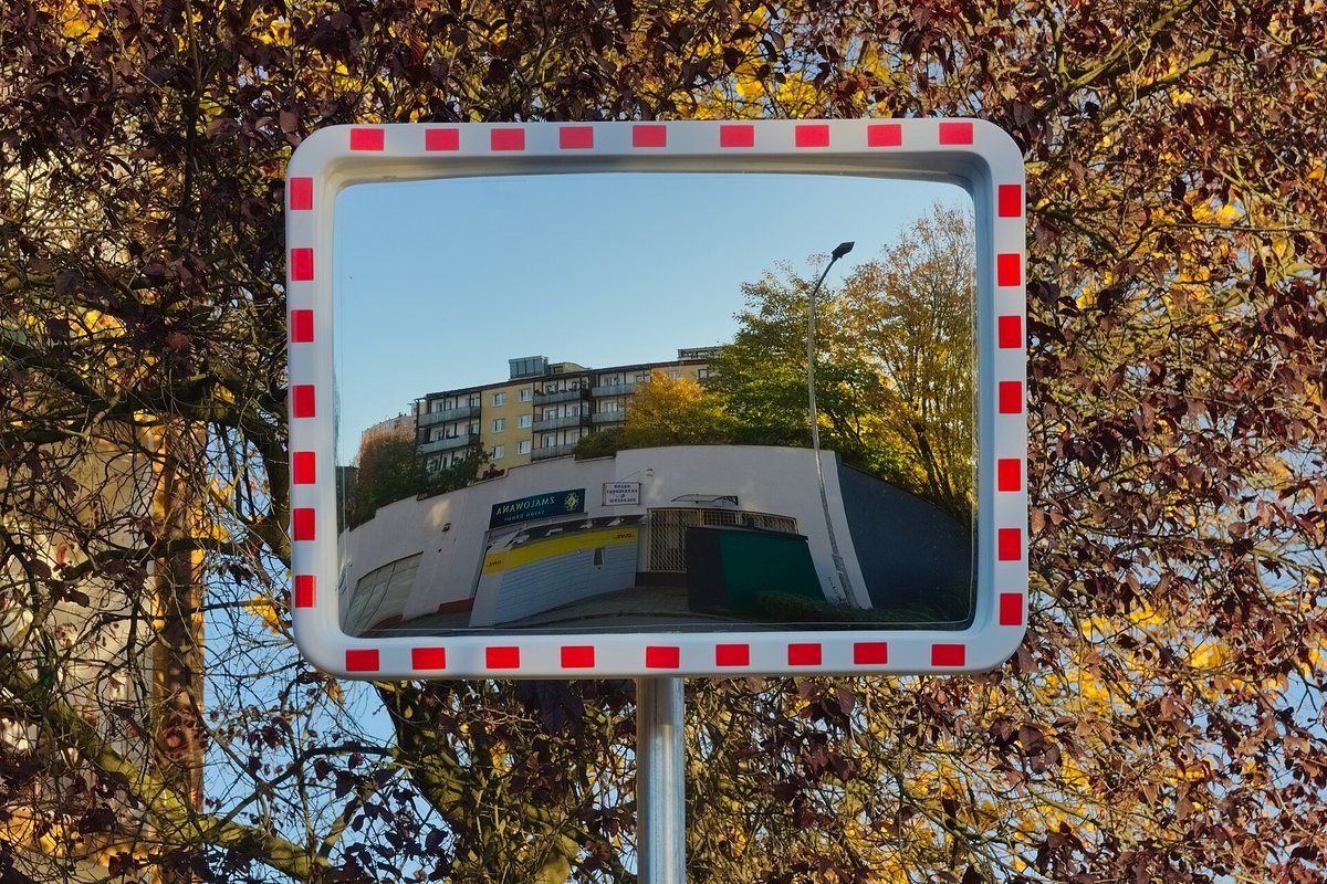 道路わきの鏡に映る建物と木