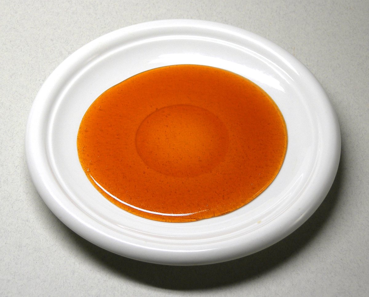 白い皿の上に広がった、とけて茶色くなった砂糖(カラメル)